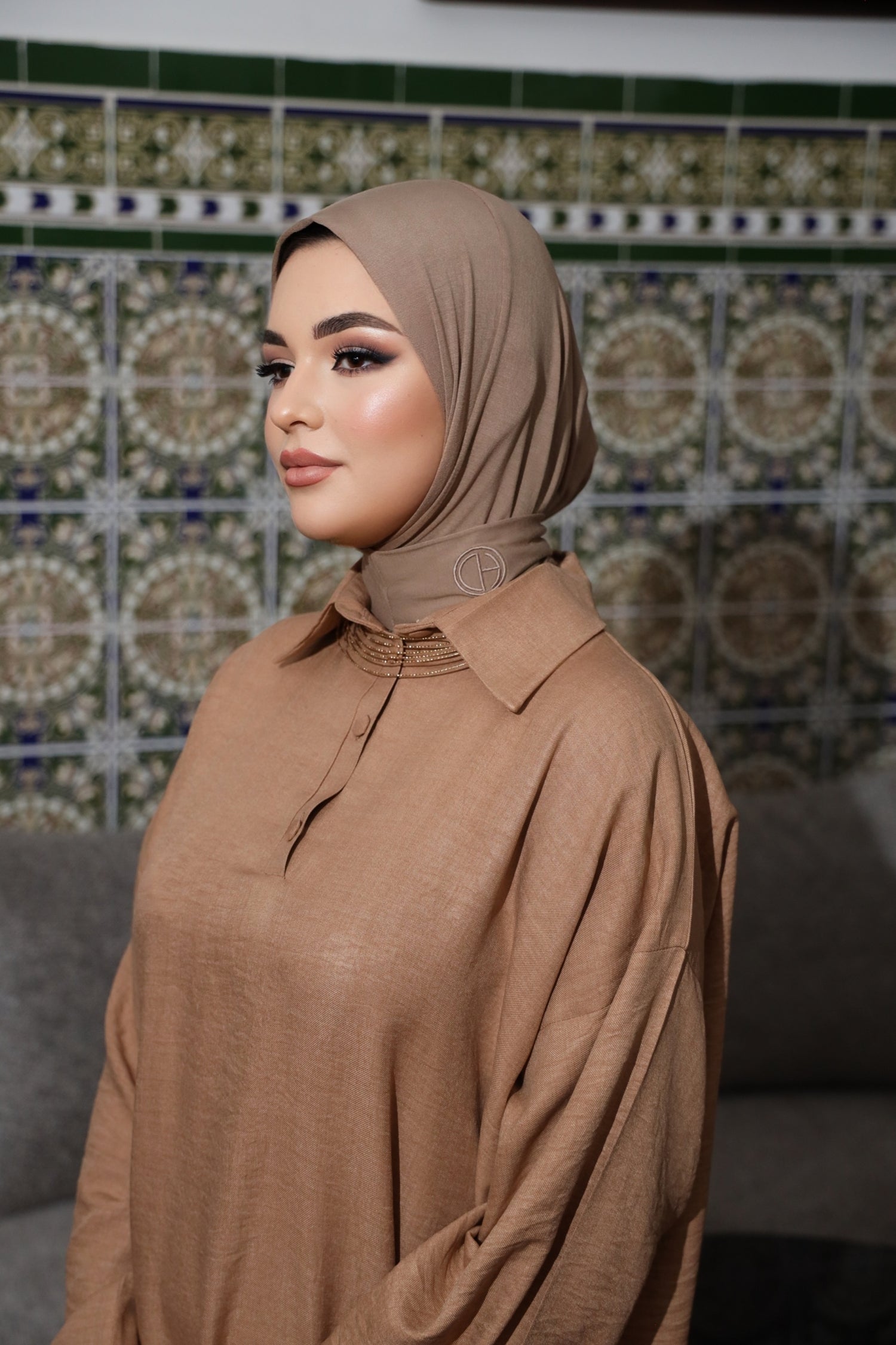 Close-up of woman wearing CHANO Modesty’s Instant Bamboo Hijab in Taupe, featuring soft bamboo jersey fabric and embroidered logo — breathable and easy to style.
