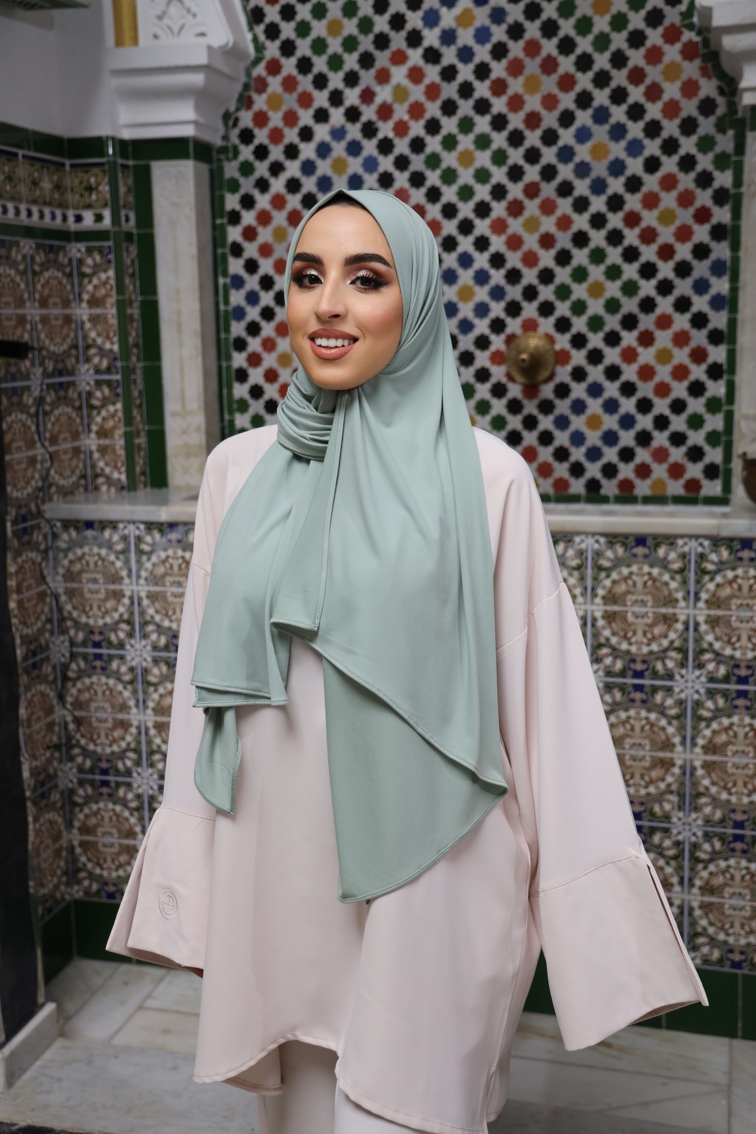 Model posing in a beige-toned twinset with wide sleeves and soft shoulder pleats.