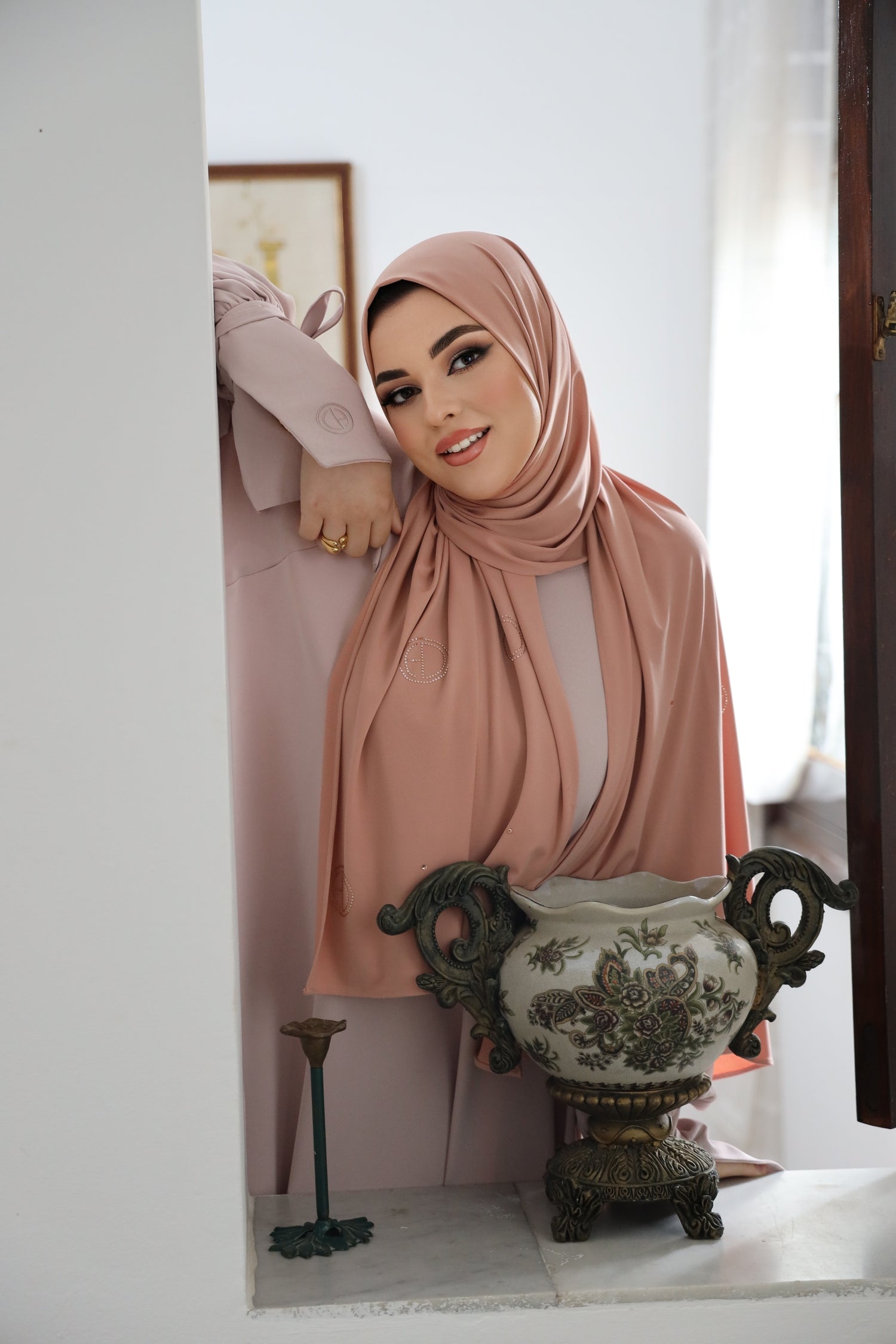 Side view of model wearing CHANO Modesty’s Stone Premium Jersey Hijab in Peach Blush with scattered crystal logo detailing, styled for a modest and luxurious everyday look.