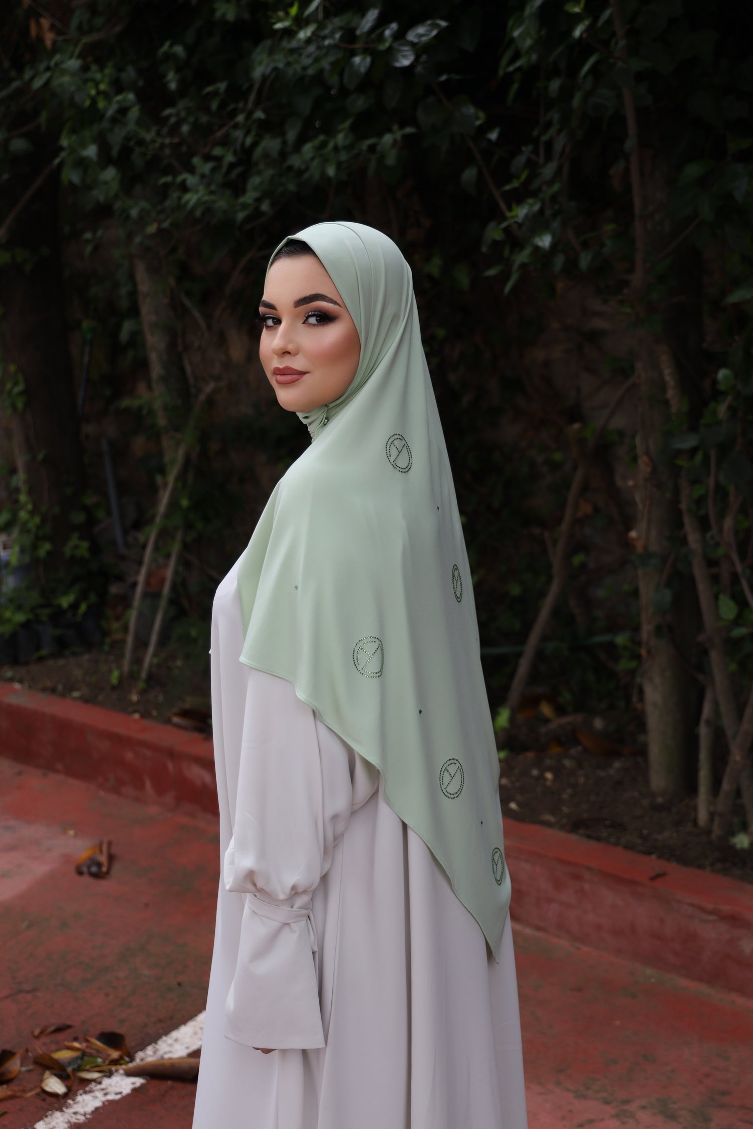 Side view of model wearing CHANO Modesty’s Stone Premium Jersey Hijab in Pastel Green with scattered crystal logo detailing, styled for a modest and luxurious everyday look.