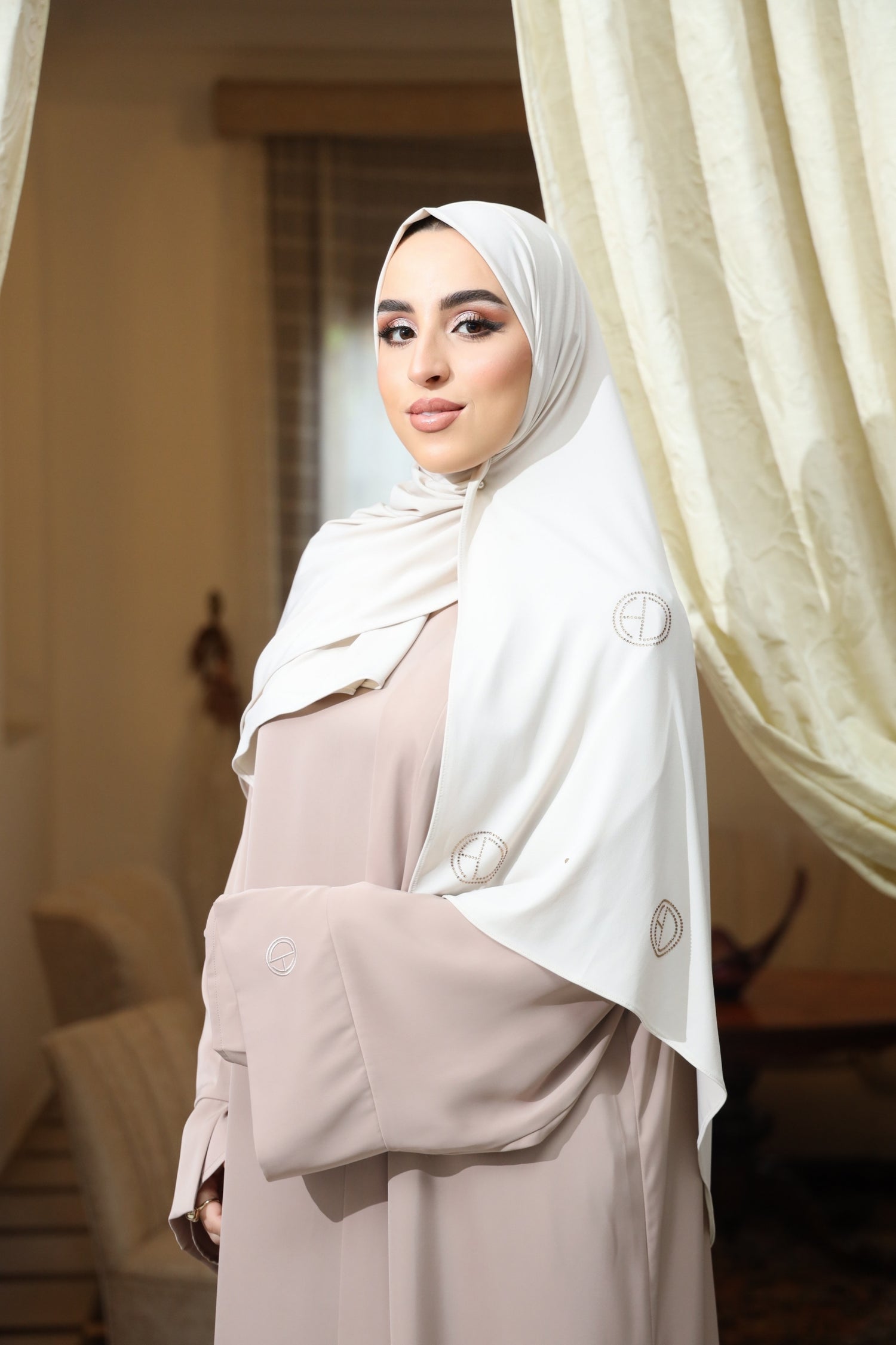 Side view of model wearing CHANO Modesty’s Stone Premium Jersey Hijab in Ivory White with scattered crystal logo detailing, styled for a modest and luxurious everyday look.