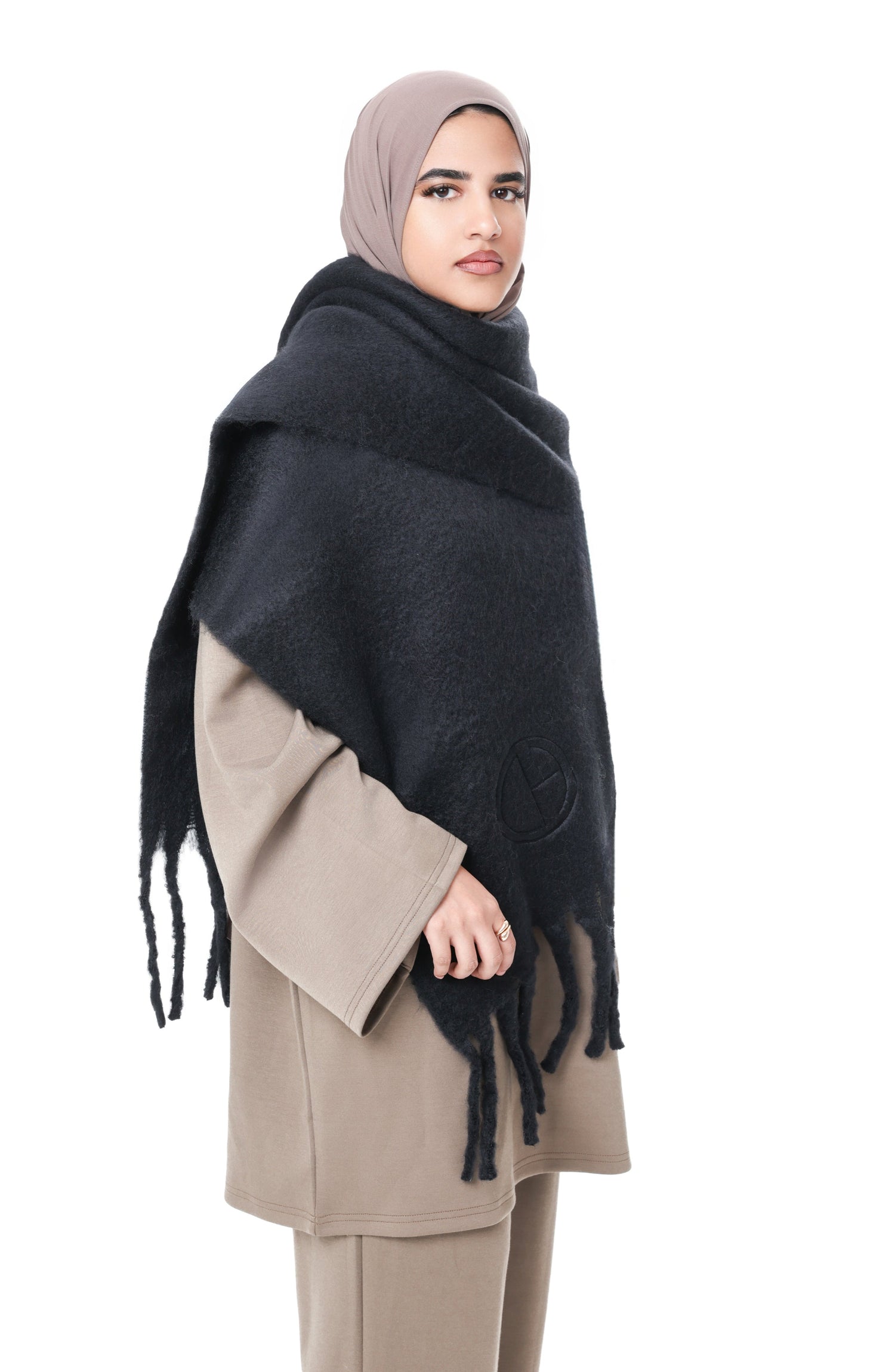Side view of model wearing the Comfy Scarf in Black over the Comfy Two-Piece Set in Taupe, showcasing the oversized fit and soft texture.