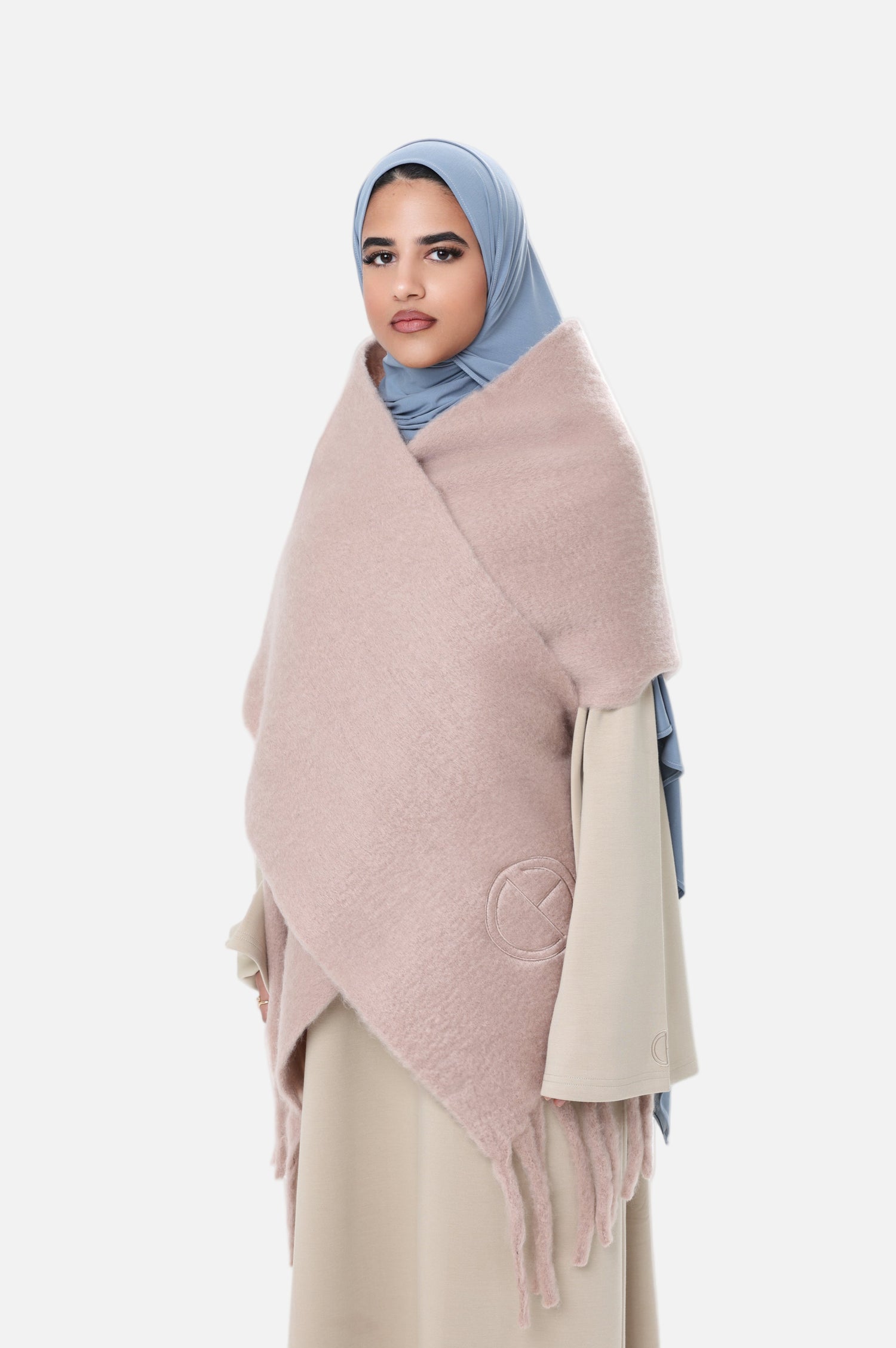Side angle of the Comfy Scarf in Beige, styled with a light beige outfit and blue hijab, emphasizing the cozy, voluminous design.