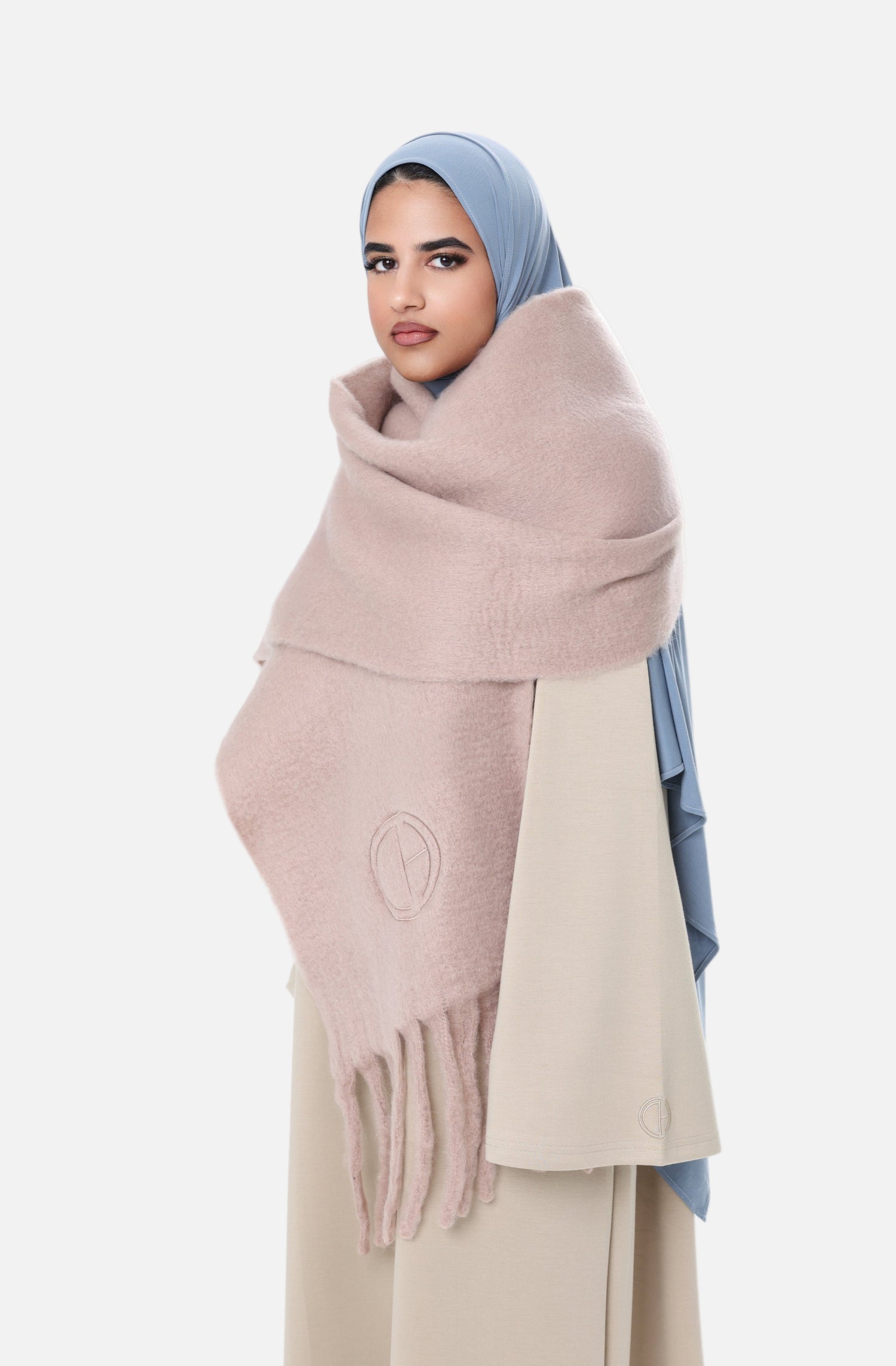 Side angle of the Comfy Scarf in Beige styled with a light beige outfit and blue hijab, emphasizing the cozy, voluminous design.