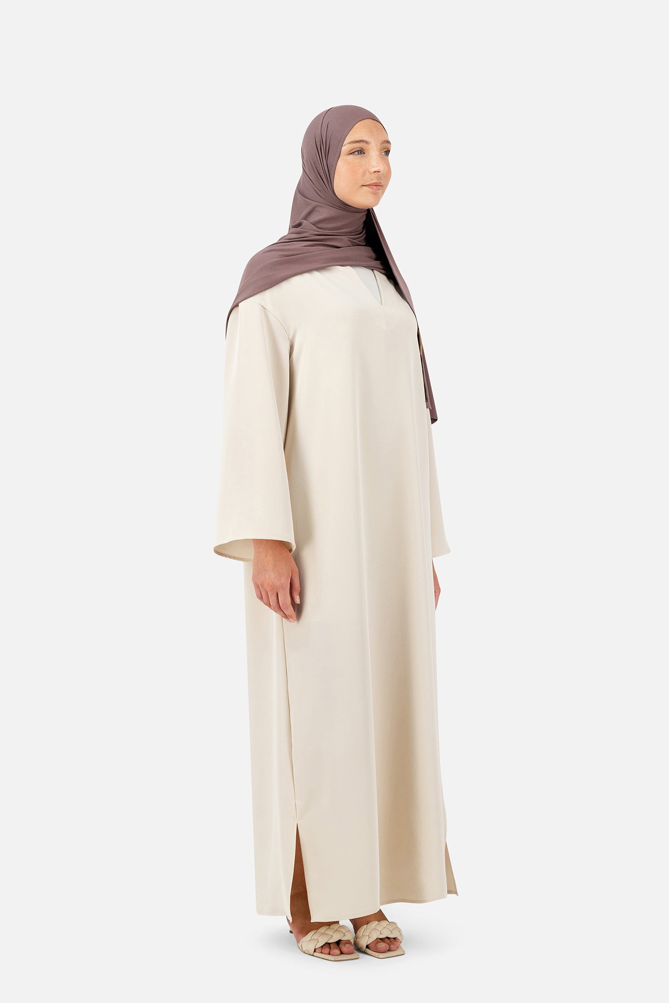 Light beige abaya set featuring layered details and full-length flowing silhouette