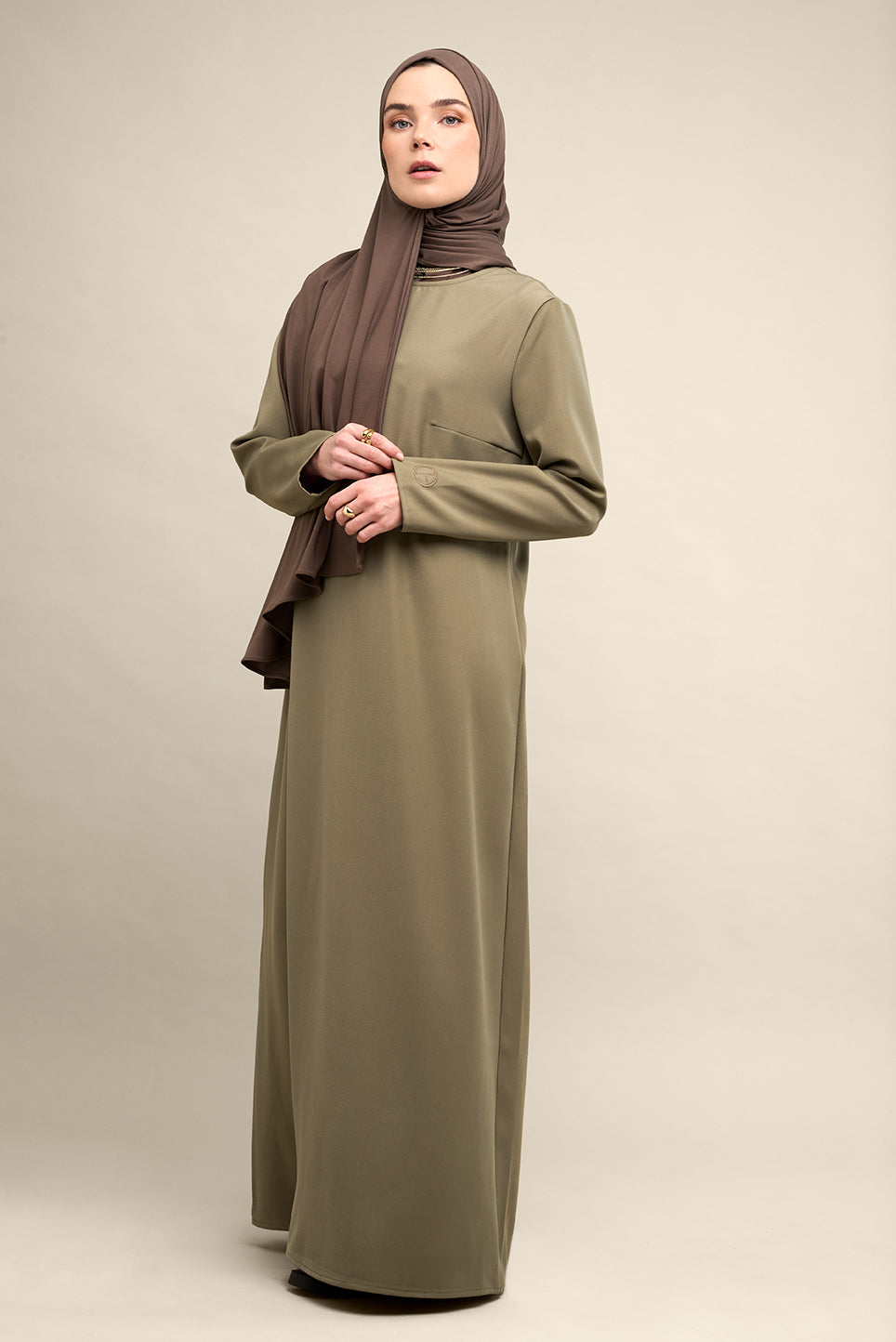 Elevate your modest wardrobe with our elegant two-piece staple abaya set in light sage. This versatile set includes a long-sleeve dress with a discreet back zipper and a classic abaya overlay that drapes beautifully for a timeless look.