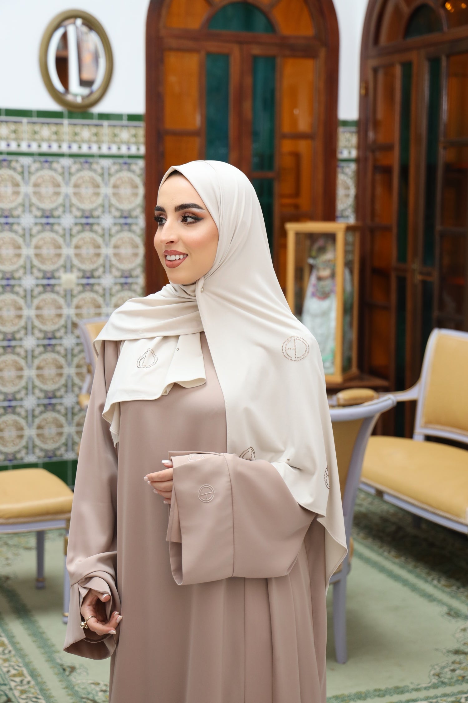 Side of model wearing two-piece satin abaya in taupe.