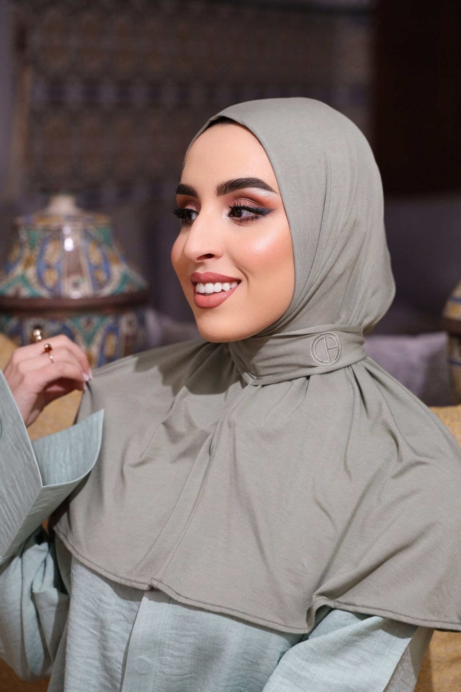 Close-up of woman wearing CHANO Modesty’s Instant Bamboo Hijab in sage green, featuring soft bamboo jersey fabric and embroidered logo — breathable and easy to style.