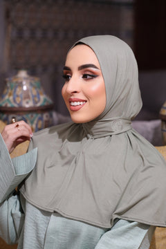 Close-up of woman wearing CHANO Modesty’s Instant Bamboo Hijab in sage green, featuring soft bamboo jersey fabric and embroidered logo — breathable and easy to style.