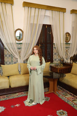 Model wearing two-piece satin abaya in soft green. 