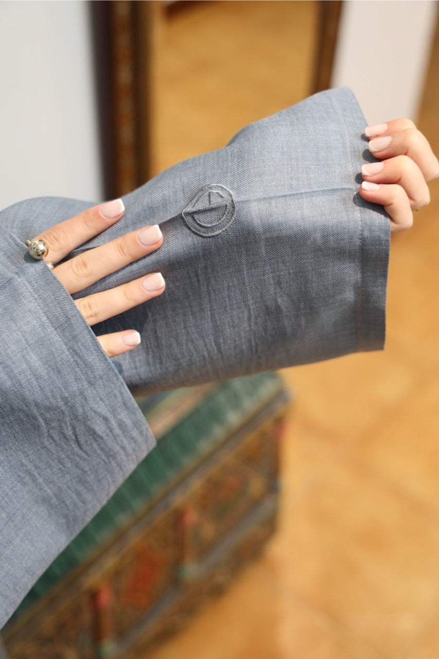 Close-up of the embroidered sleeve detail of the steel blue tunic dress. 