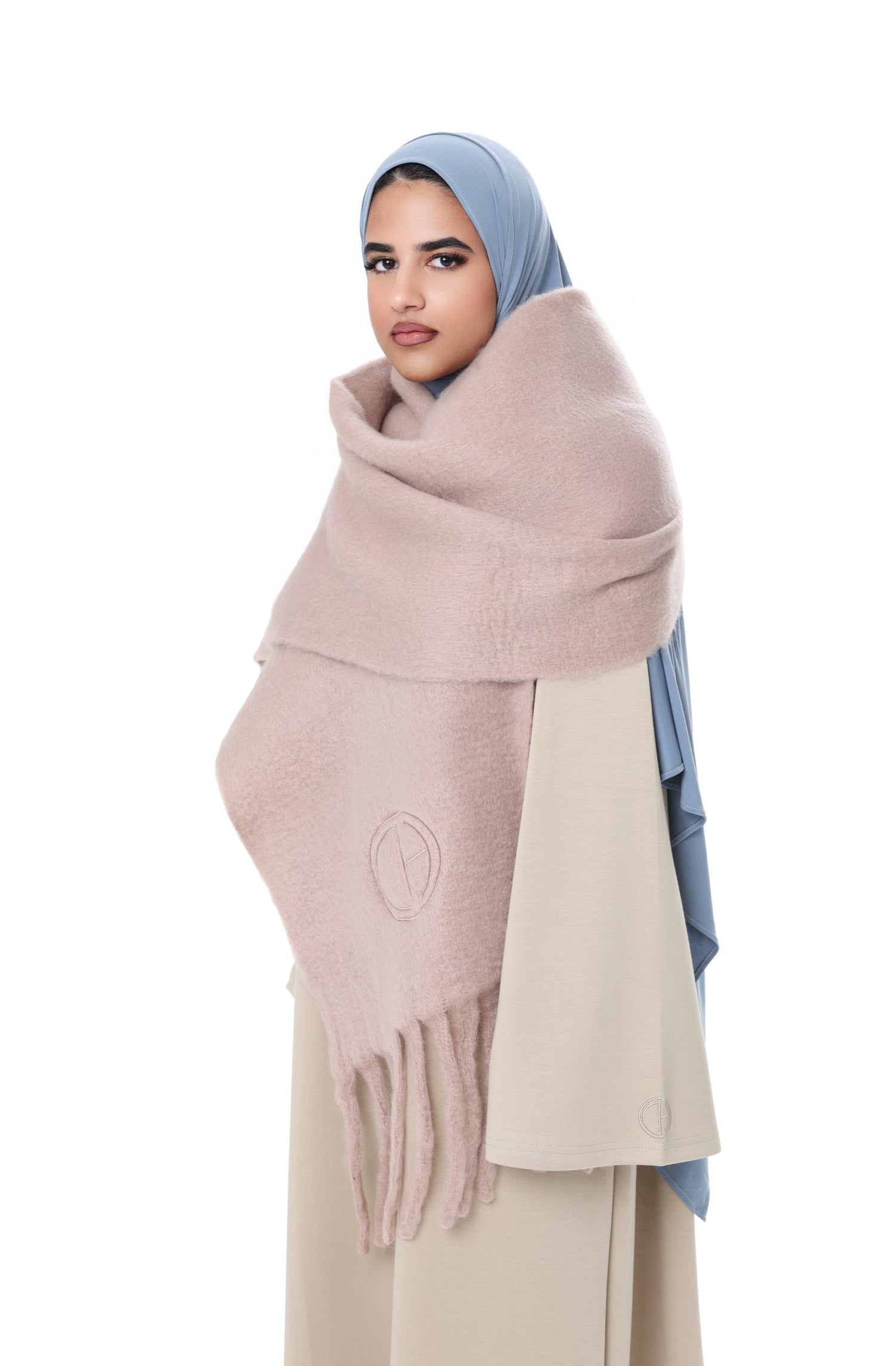 Side angle of the Comfy Scarf in Beige styled with a light beige outfit and blue hijab, emphasizing the cozy, voluminous design.