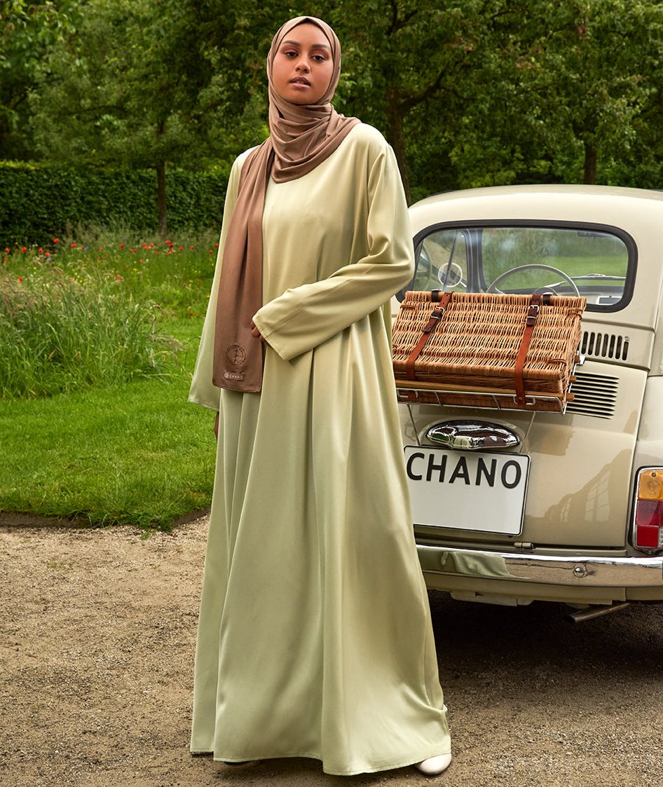 De tweedelige satijnen abaya van CHANO in de kleur licht groen is gemaakt van een prachtige mat satijnen stof met een subtiele glans. De soepel vallende stof voelt comfortabel aan. 