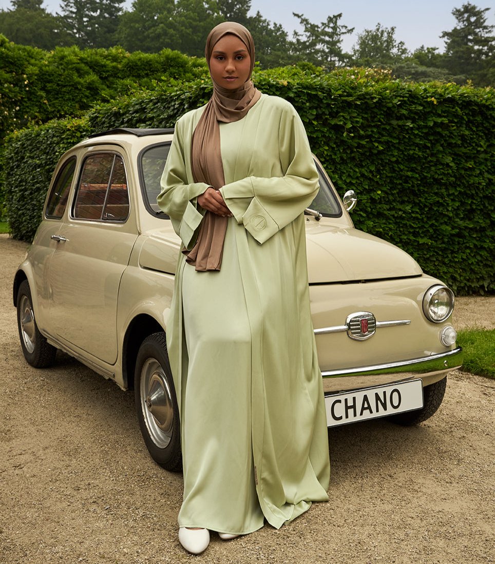 De tweedelige satijnen abaya van CHANO in de kleur licht groen is gemaakt van een prachtige mat satijnen stof met een subtiele glans. De soepel vallende stof voelt comfortabel aan. 