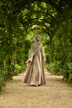 De tweedelige satijnen abaya van CHANO in de kleur Taupe is gemaakt van een prachtige mat satijnen stof met een subtiele glans. De soepel vallende stof voelt comfortabel aan. 