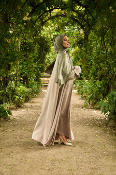 De tweedelige satijnen abaya van CHANO in de kleur Taupe is gemaakt van een prachtige mat satijnen stof met een subtiele glans. De soepel vallende stof voelt comfortabel aan. 