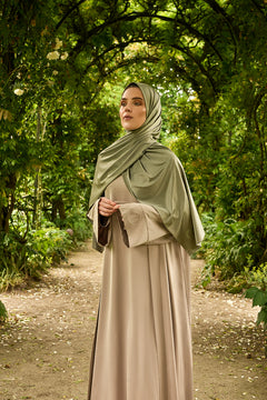 De tweedelige satijnen abaya van CHANO in de kleur Taupe is gemaakt van een prachtige mat satijnen stof met een subtiele glans. De soepel vallende stof voelt comfortabel aan. 
