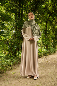De tweedelige satijnen abaya van CHANO in de kleur Taupe is gemaakt van een prachtige mat satijnen stof met een subtiele glans. De soepel vallende stof voelt comfortabel aan. 