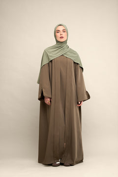 Elevate your modest wardrobe with our elegant two-piece staple abaya set in brown taupe. This versatile set includes a long-sleeve dress with a discreet back zipper and a classic abaya overlay that drapes beautifully for a timeless look.