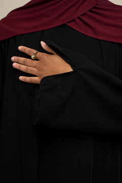 Elevate your modest wardrobe with our elegant two-piece staple abaya set in black. This versatile set includes a long-sleeve dress with a discreet back zipper and a classic abaya overlay that drapes beautifully for a timeless look.