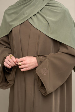 Elevate your modest wardrobe with our elegant two-piece staple abaya set in brown taupe. This versatile set includes a long-sleeve dress with a discreet back zipper and a classic abaya overlay that drapes beautifully for a timeless look.